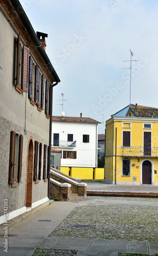 Small Italian town Comacchio also known as "The Little Venice", Emilia Romagna region, province of Ferrara, Italy: Colored houses in traditional architectural style