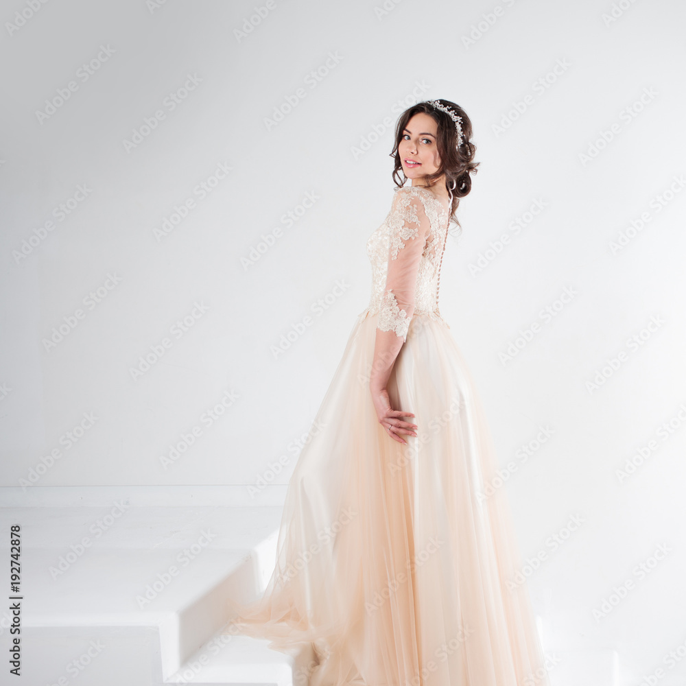 Portrait of a beautiful girl in a wedding dress. Bride in a luxurious dress standing on the stairs, climb up Portrait of a beautiful girl in a wedding dress. Bride in a luxurious dress standing on the stairs, climb up