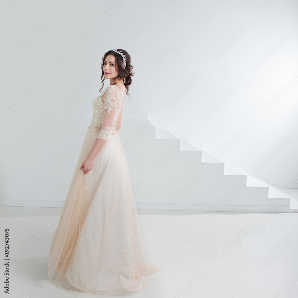 Portrait of a beautiful girl in a wedding dress. Bride in a luxurious dress, in a beautiful white interior Portrait of a beautiful girl in a wedding dress. Bride in a luxurious dress, in a beautiful white interior