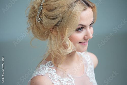 Portrait of a beautiful girl in a wedding dress. Bride in a luxurious dress on a white background, close-up