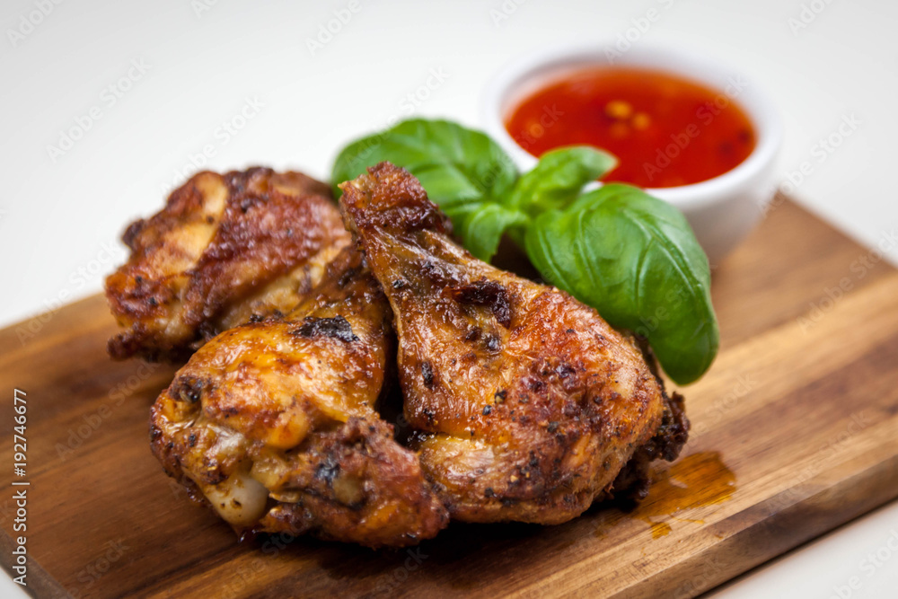 Chicken wings with sweet chilli sauce on the wooden cutting board Chicken wings with sweet chilli sauce on the wooden cutting board