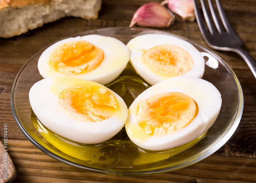 hard boiled eggs cut in half with oil and vinegar, on wooden board hard boiled eggs cut in half with oil and vinegar, on wooden board