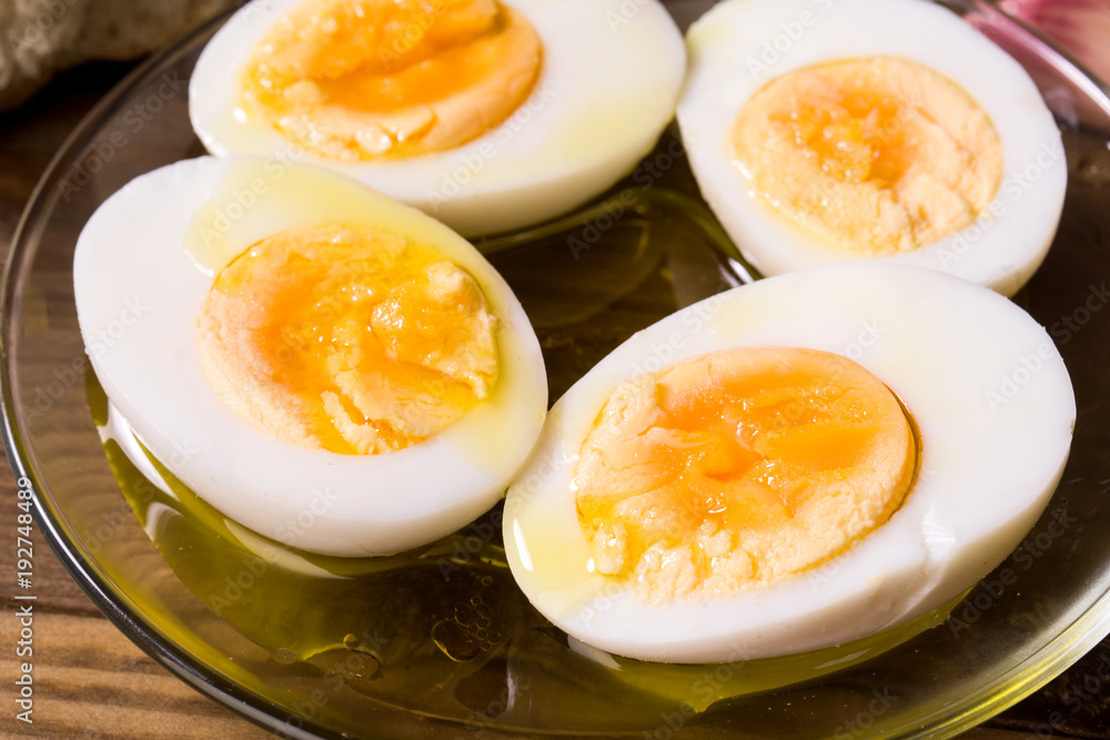 hard boiled eggs cut in half with oil and vinegar, on wooden board hard boiled eggs cut in half with oil and vinegar, on wooden board