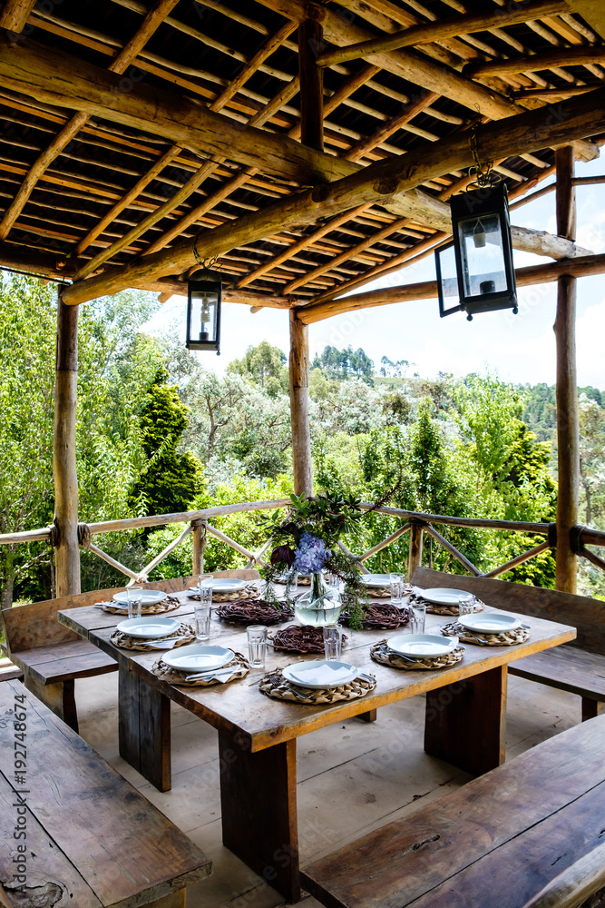 Table set in an outside hut with beatiful views to the forest Table set in an outside hut with beatiful views to the forest