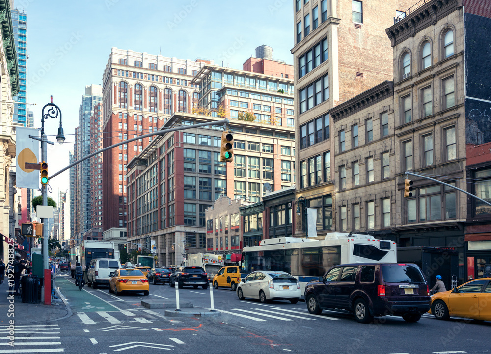 Fototapeta premium Życie miasta i ruch na alei Manhattan (Ladies 'Mile Historic District) w świetle dziennym, Nowy Jork, Stany Zjednoczone. Stonowany obraz.