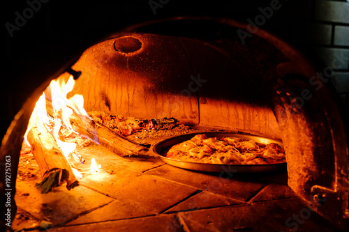 Brick oven with hot pizza cooking inside