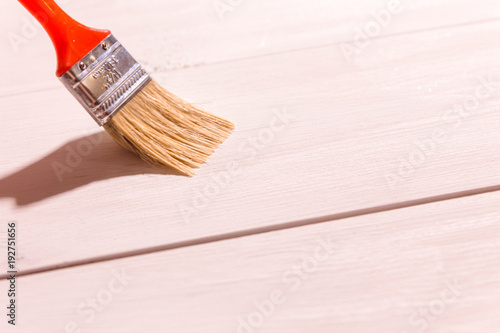 man hand with a paintbrush on wooden background