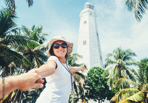 Dondra lighthouse in Sri Lanka: woman traveler take for hand her boyfreind and goes to lighthouse photo