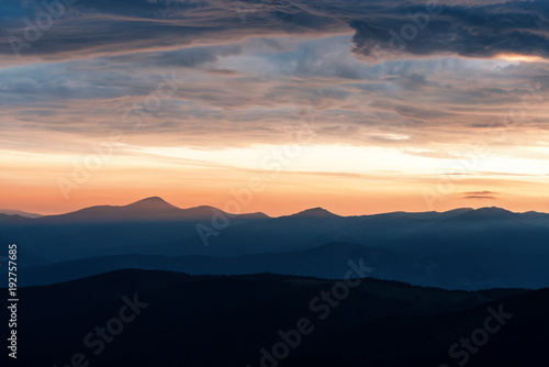 Picturesque summer landscape with colorful sunrise on Carpathian mountains. Mountain ranges in morning light. Travel background concept