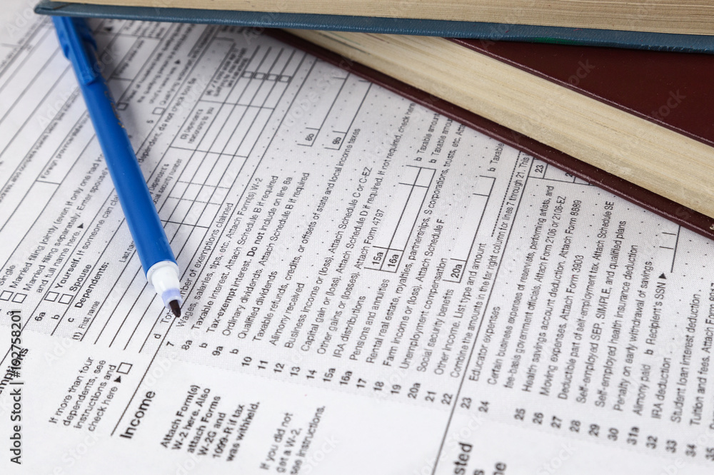 Business finance concept. 1040 tax form and a blue pen Business finance concept. 1040 tax form and a blue pen