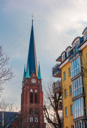 old church tower next to an apartment house