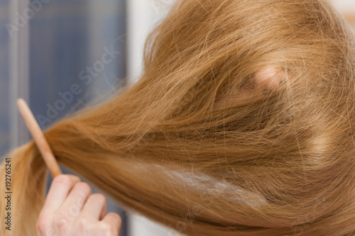 Woman face covered with blonde long hair