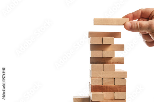 Wood block tower game on white background. Planning, risk and strategy of project management in business, businessman and engineer gambling placing wooden block on a tower. Construction concept.