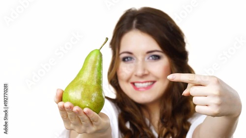 Smiling woman holding and recommend to eat pear fruit, isolated on white. Healthy eating, vegan food, dieting concept. photo