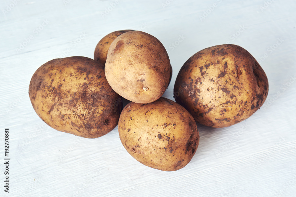 Fresh organic young potatoes on white wooden background Fresh organic young potatoes on white wooden background