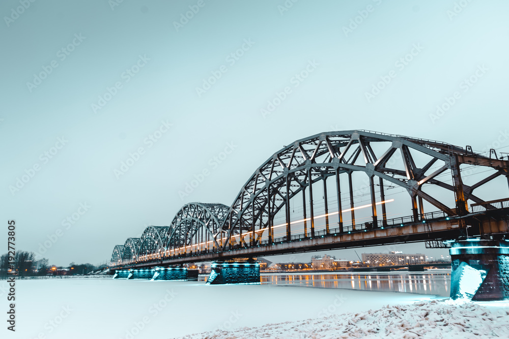 Obraz premium main bridgein Riga connecting the two sides of the city. Long exposure shot during the golden hour after sunrise