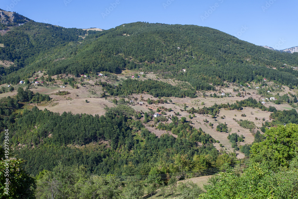 View of a valley with rural houses in the mountains of Montenegro 