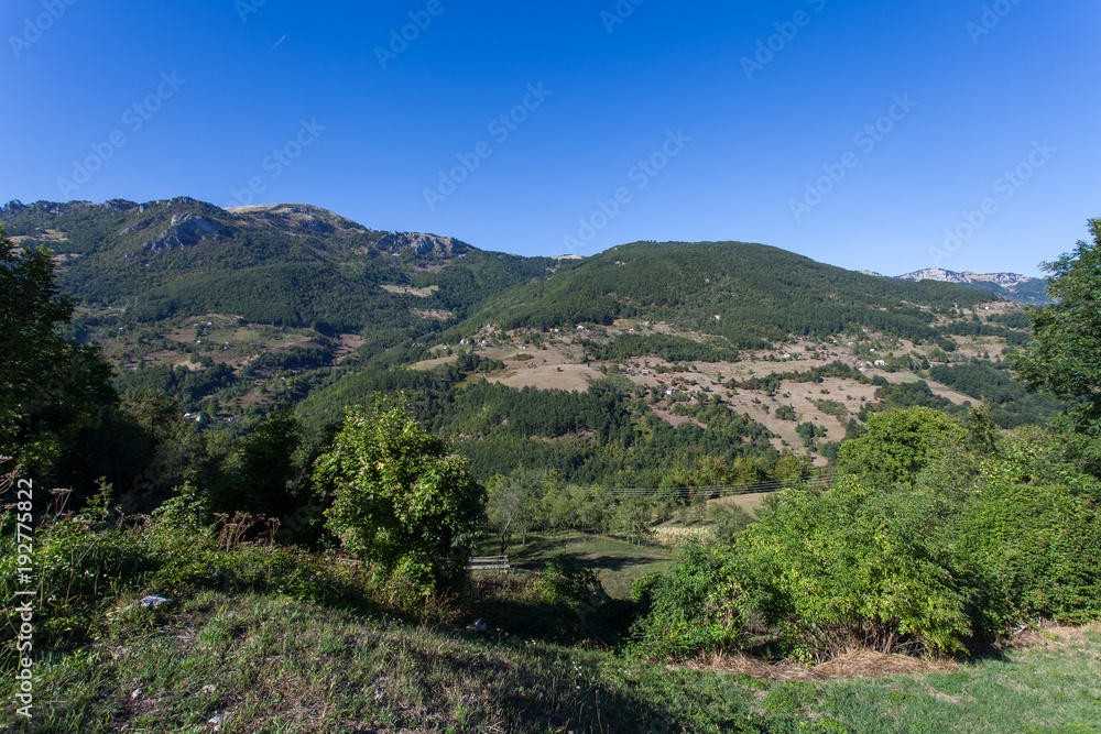 View of a valley with rural houses in the mountains of Montenegro 