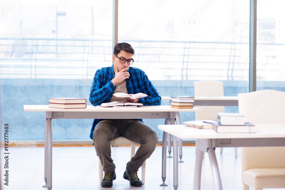 Student studying in the empty library with book preparing for ex Student studying in the empty library with book preparing for ex
