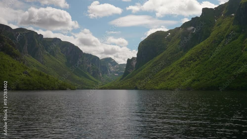 Very tall granite rocky cliffs western brook pond in Gros Morne panning Very tall granite rocky cliffs western brook pond in Gros Morne panning