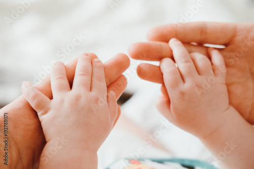 Cute newborn baby holding mother s hand while sleeping. Happy Family concept.