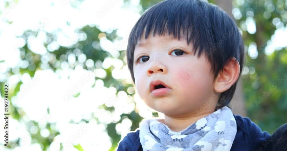 mother carrying baby son with sun light blur bokeh background, close-up face asian cute child boy mother carrying baby son with sun light blur bokeh background, close-up face asian cute child boy