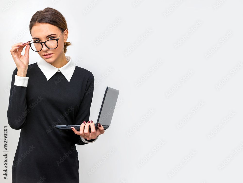 The girl with glasses and a laptop working in the office. Space for copyspace The girl with glasses and a laptop working in the office. Space for copyspace