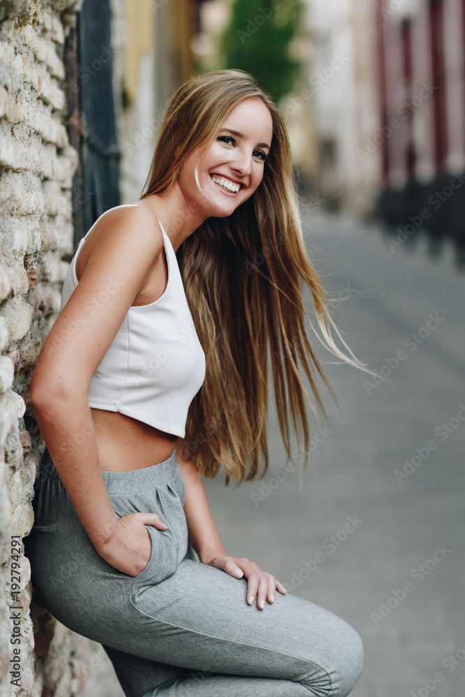Smiling blonde girl with straight hair in urban background Smiling blonde girl with straight hair in urban background