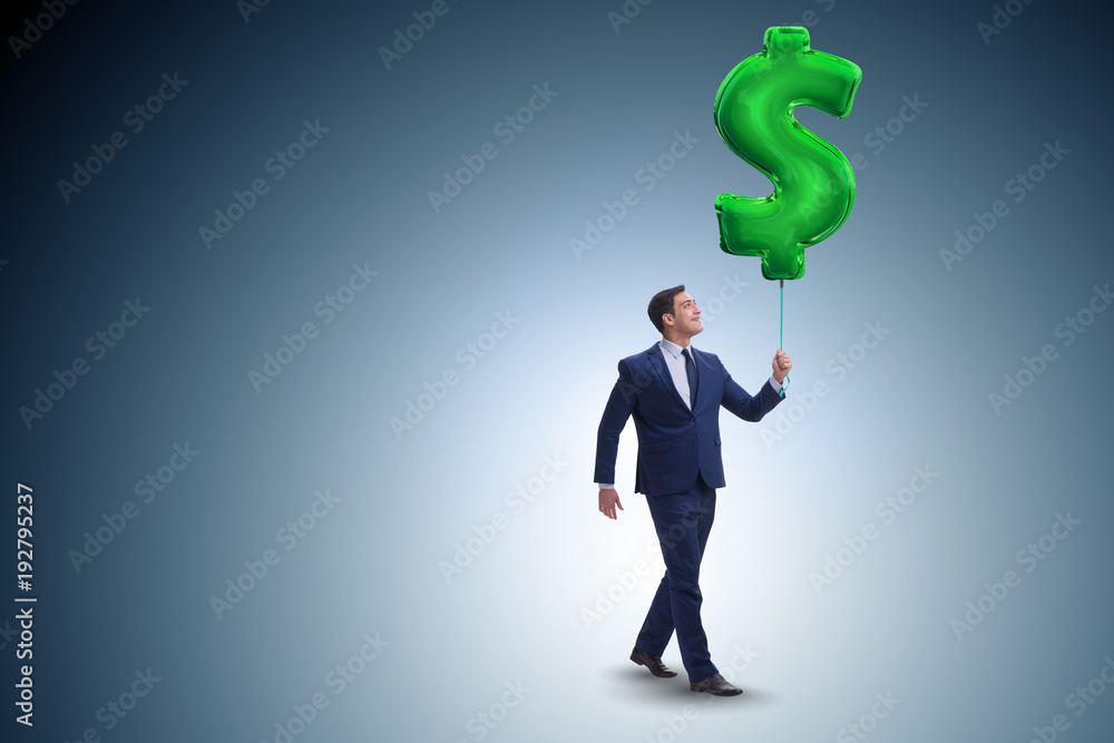 Businessman walking with inflatable dollar sign Businessman walking with inflatable dollar sign