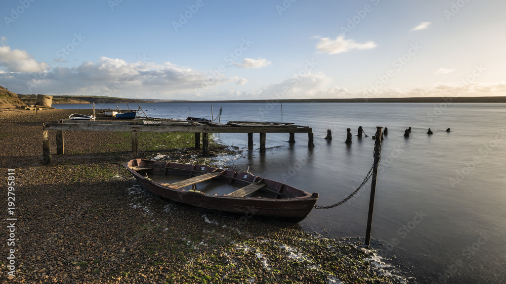 Beautiful vibrant sunset landscape image of boats moored in Fleet Lagoon in Dorset England