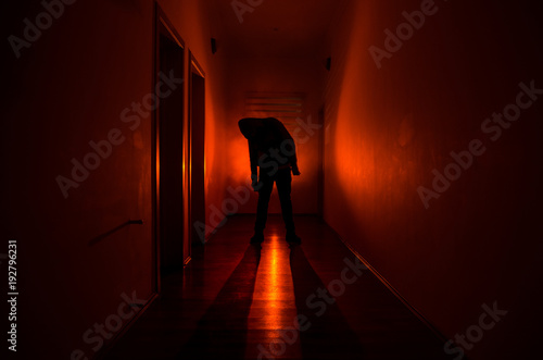 Dark corridor with cabinet doors and lights with silhouette of spooky horror man standing with different poses. photo
