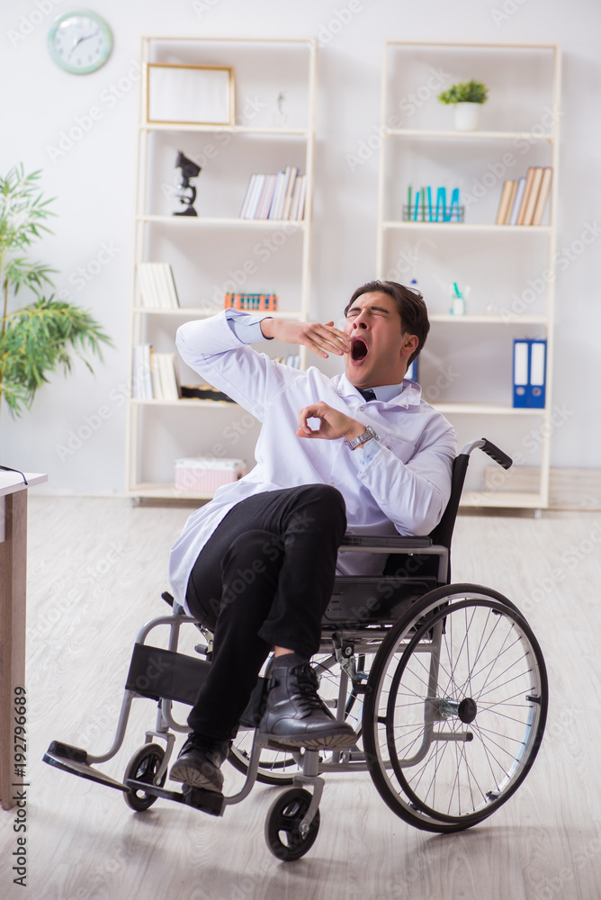 Doctor resting on wheelchair in hospital after night shift Doctor resting on wheelchair in hospital after night shift