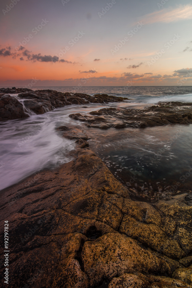 Fototapeta premium Long Exposure sunrise, colorful sky, volcanic rock beautiful seascape at Gran Canaria Island Coast in Spain.