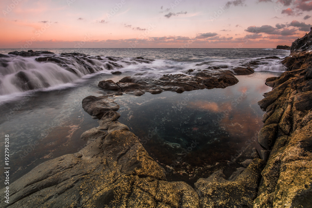 Long Exposure sunrise, colorful sky, volcanic rock beautiful seascape at Gran Canaria Island Coast in Spain.