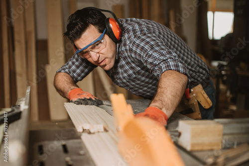 carpenter works with manual and electric equipment photo