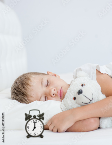 little boy sleeping in bed with toy bear. Space for text