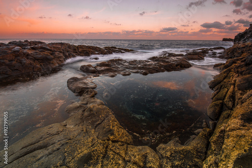 Long Exposure sunrise, colorful sky, volcanic rock beautiful seascape at Gran Canaria Island Coast in Spain.