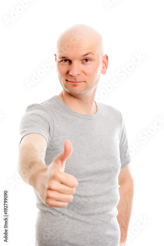 man with bald head and thumb up is looking friendly in to the camera