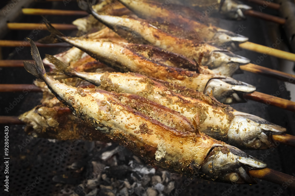 Barbecue with fish. Grilled fish (mackerel) on a stick