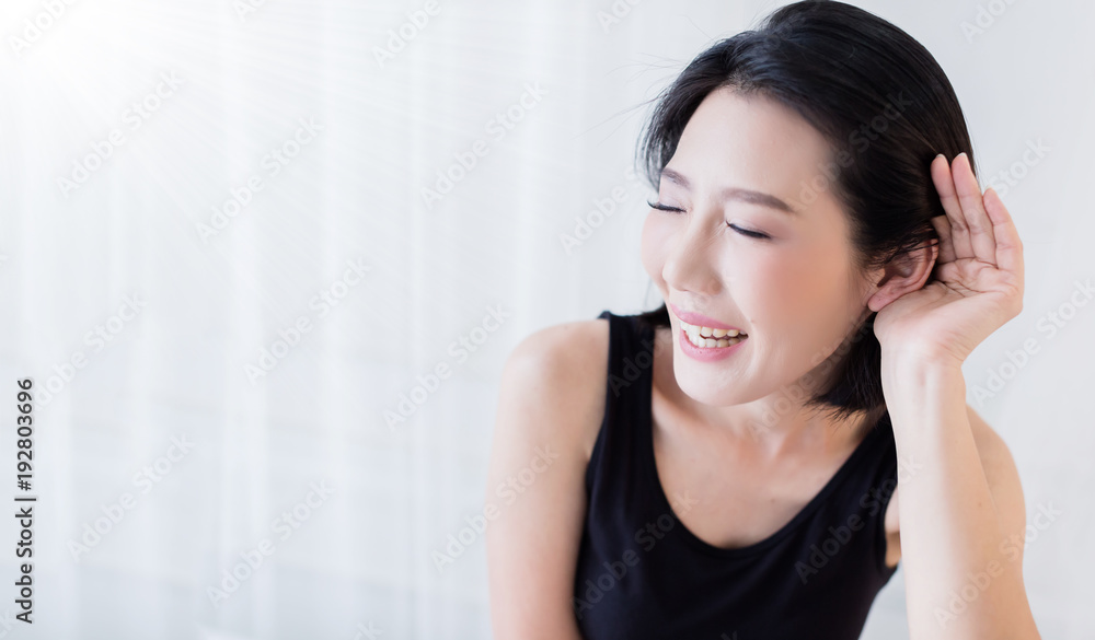beautiful asian woman in black vest portrait with happiness action on bed with white room background beautiful asian woman in black vest portrait with happiness action on bed with white room background