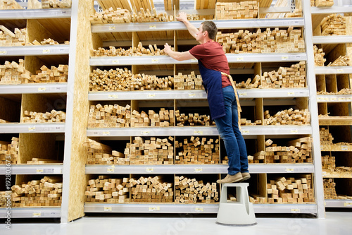 Принти на полотні worker or seller in construction store or warehouse wood section at work