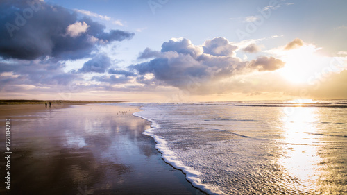 Walking along the beach during sunset in IJmuiden the Netherlands, photo