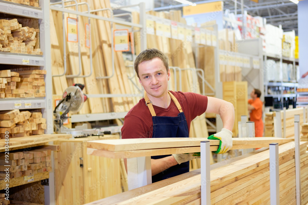 worker or seller in construction store or warehouse wood department at work worker or seller in construction store or warehouse wood department at work