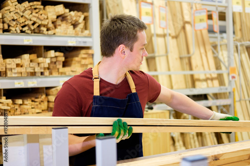 Canvastavla worker or seller in construction store or warehouse wood department at work