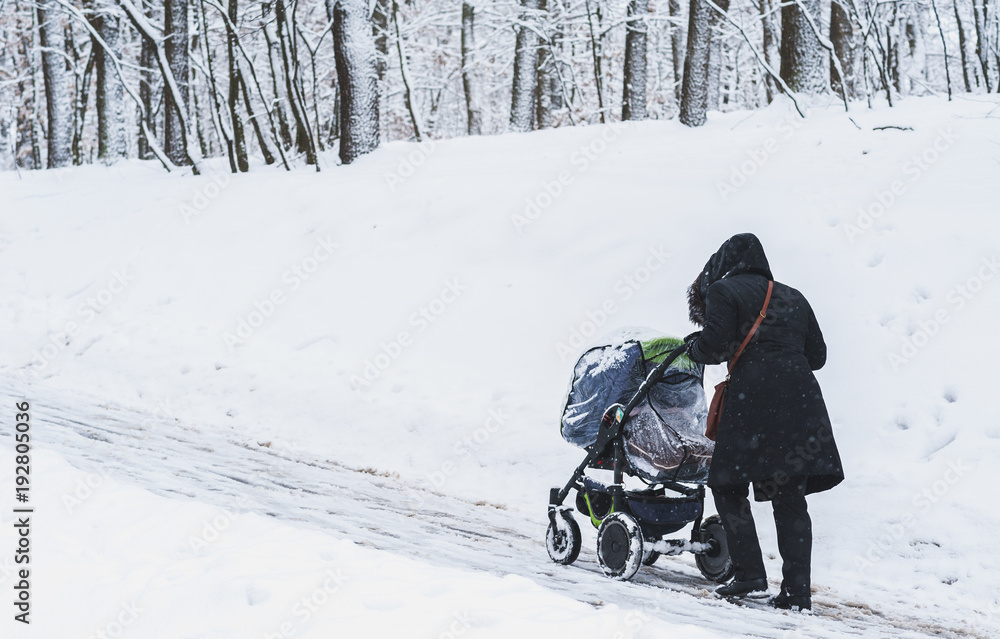 A woman with a stroller in winter