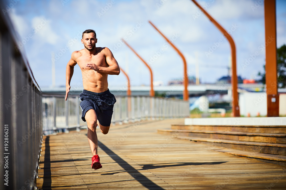 Athletic man sprinting, running outdoors in the city