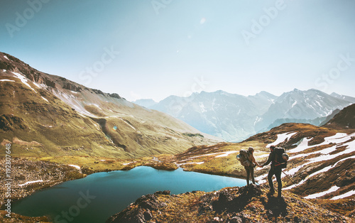 Couple travelers holding hands on mountain cliff over lake together love and Travel Lifestyle wanderlust concept adventure vacations outdoor aerial view. photo