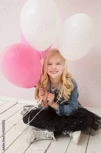 Happy cute little girl  with pink balloon heart on a pink background. mother's day, birthday