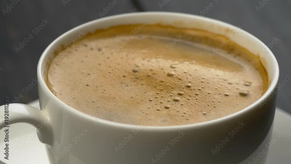 Splashes of coffee in white espresso coffee cup. Drops of coffee falls into the foam. Close-up shot.
Splashes of coffee in white espresso coffee cup. Drops of coffee falls into the foam. Close-up shot.