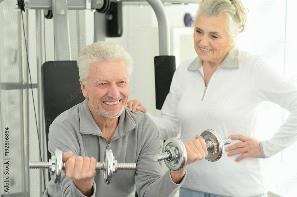 senior couple exercising in gym senior couple exercising in gym